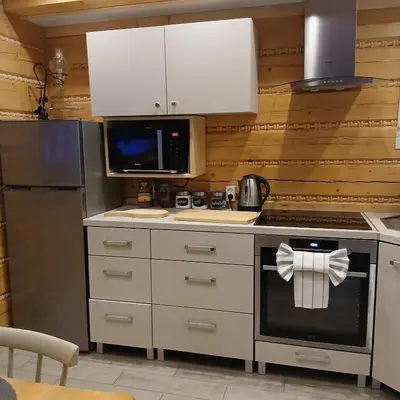a kitchen with white cabinets and a stove top oven at Piernikowa Chata in Zawoja