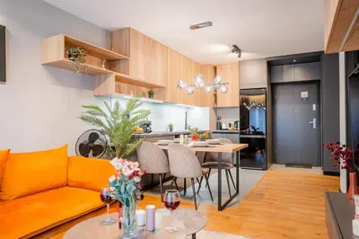 a living room and kitchen with a couch and a table at Kraków Podgórze Apt - Parking, Balcony - by Rentujemy in Kraków