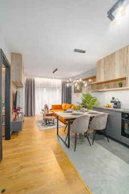 a kitchen and living room with a table and chairs at Kraków Podgórze Apt - Parking, Balcony - by Rentujemy in Kraków