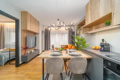 a kitchen and living room with a table and chairs at Kraków Podgórze Apt - Parking, Balcony - by Rentujemy in Kraków