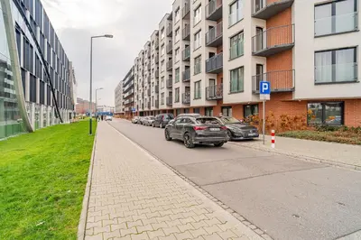a street with cars parked on the side of a building at Kraków Podgórze Apt - Parking, Balcony - by Rentujemy in Kraków