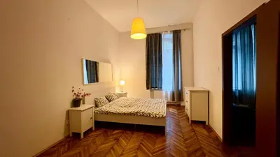 a bedroom with a bed and two windows at Next to Main Square 2 in Kraków