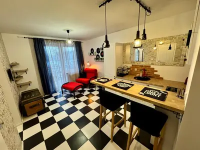 a kitchen with a black and white checkered floor at LOFT Studio Wielicka in Kraków
