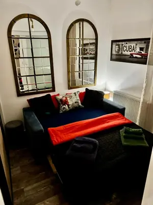a bedroom with a bed and two windows and a couch at LOFT Studio Wielicka in Kraków