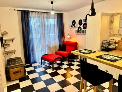 a living room with a checkered floor and red chairs at LOFT Studio Wielicka in Kraków