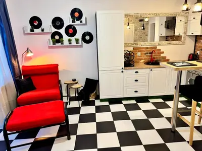 a kitchen with a red chair and a table at LOFT Studio Wielicka in Kraków