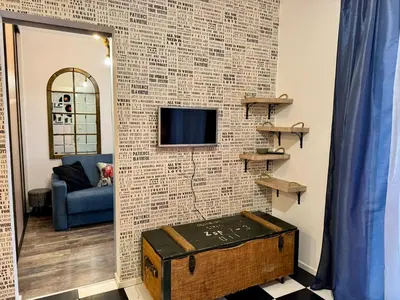 a room with a brick wall with a tv and a trunk at LOFT Studio Wielicka in Kraków