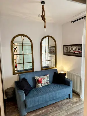 a blue couch in a living room with two mirrors at LOFT Studio Wielicka in Kraków