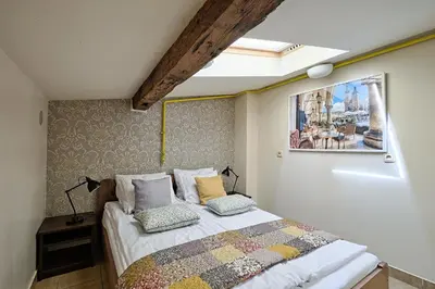 a bedroom with a bed and a picture on the wall at Urban Nest - Double Room in the Attic in Kraków