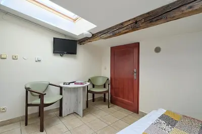 a room with a bed and a table and chairs at Urban Nest - Double Room in the Attic in Kraków
