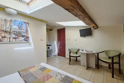 a bedroom with a bed and two chairs and a table at Urban Nest - Double Room in the Attic in Kraków