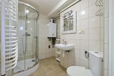 a bathroom with a toilet and a sink and a shower at Urban Nest - Double Room in the Attic in Kraków