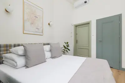 a white bedroom with a white bed with pillows at Studio apartment - Augustiańska 1 street in Kraków