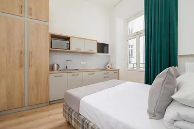 a bedroom with a bed and a kitchen with a sink at Studio apartment - Augustiańska 1 street in Kraków