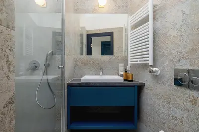 a bathroom with a sink and a shower with a mirror at Studio apartment with mezzanine - Augustianska 1 in Kraków