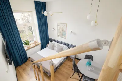 a small room with a bed and a table at Studio apartment with mezzanine - Augustianska 1 in Kraków