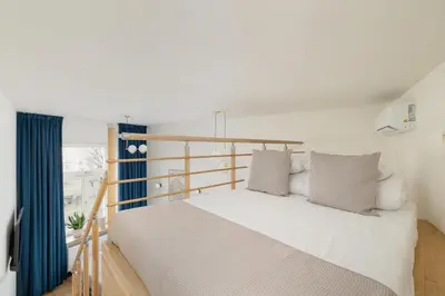 a bedroom with a white bed and a balcony at Studio apartment with mezzanine - Augustianska 1 in Kraków