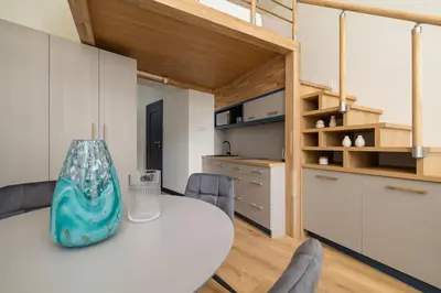 a kitchen and dining room with a table and chairs at Studio apartment with mezzanine - Augustianska 1 in Kraków