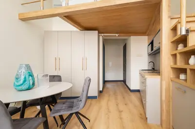 a kitchen and dining room with a table and chairs at Cozy studio - Augustiańska 1 street in Kraków