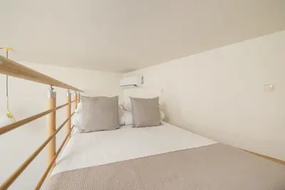 a small bed in a room with white walls at Cozy studio - Augustiańska 1 street in Kraków