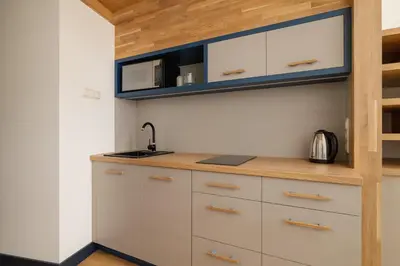a kitchen with white cabinets and a sink at Cozy studio - Augustiańska 1 street in Kraków