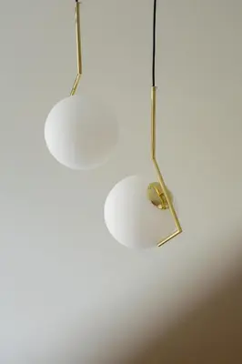 two lights are hanging from a white ceiling at Cozy studio - Augustiańska 1 street in Kraków