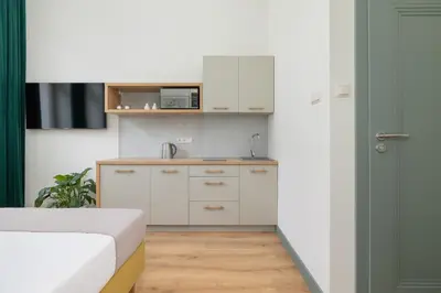 a small kitchen with white cabinets and a sink at Kazimierz - Augustiańska 1 street in Kraków