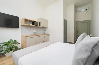 a bedroom with a white bed and a tv at Kazimierz - Augustiańska 1 street in Kraków
