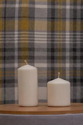 two white candles sitting on a wooden shelf at Kazimierz - Augustiańska 1 street in Kraków