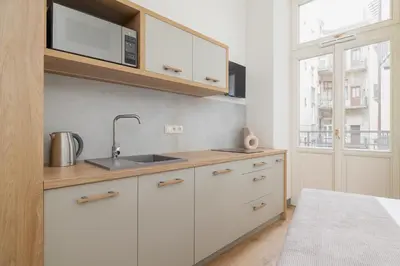 a kitchen with white cabinets and a sink and a window at Studio - Augustiańska 1 in Kraków
