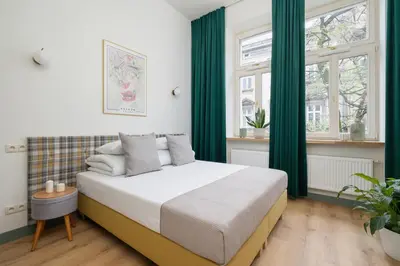 a bedroom with a bed with green curtains at Studio - Augustiańska 1 - Kazimierz in Kraków