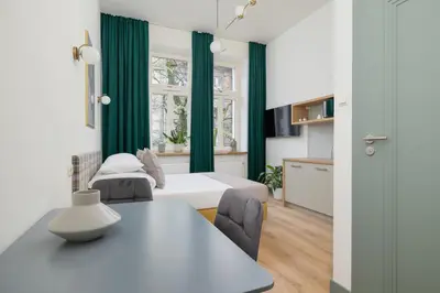 a bedroom with a bed and a table with chairs at Studio - Augustiańska 1 - Kazimierz in Kraków
