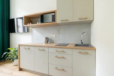 a kitchen with white cabinets and a sink at Studio - Augustiańska 1 - Kazimierz in Kraków