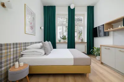 a bedroom with a bed with green drapes at Studio - Augustiańska 1 - Kazimierz in Kraków