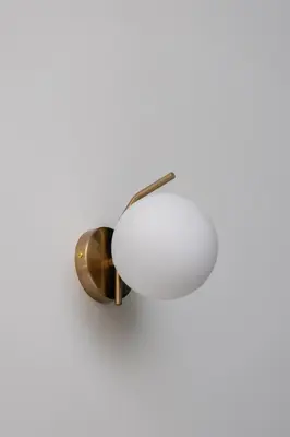 a white and gold lamp on a white wall at Studio - Augustiańska 1 - Kazimierz in Kraków