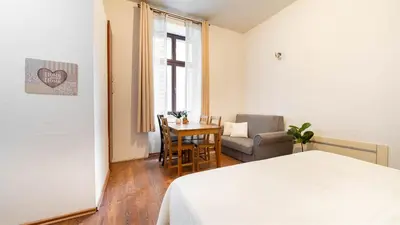 a bedroom with a bed and a table and a chair at Old Anser City in Kraków