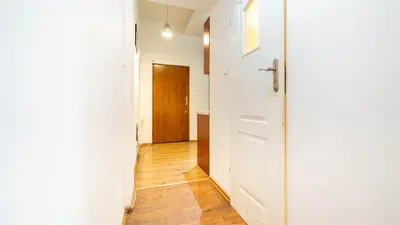 a hallway with a door and a wooden floor at Old Anser City in Kraków