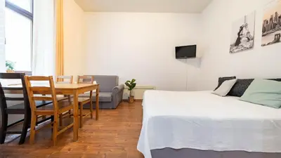 a bedroom with a bed and a table and a tv at Old Anser City in Kraków