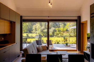 a living room with a couch and a large window at Domki nad potokiem in Lipnica Murowana