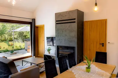 a living room with a table and a fireplace at Domki nad potokiem in Lipnica Murowana