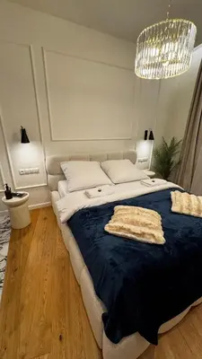 a bedroom with a large bed with a blue blanket at Wawel Love & Bath Apartment in Kraków