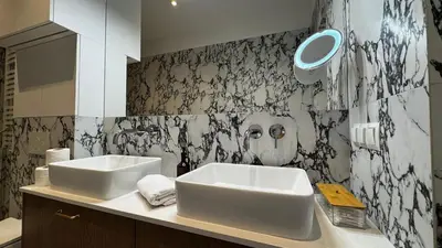 a bathroom with a black and white patterned wall at Wawel Love & Bath Apartment in Kraków