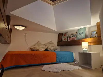 a bedroom with a bed with an orange and blue blanket at The Hidden Echo Studio Kazimierz, #Netflix # AC# in Kraków