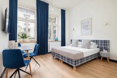 a bedroom with a bed and a table and chairs at 1-bedroom apartment - Augustiańska 1 street in Kraków