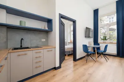 a kitchen with a sink and a table with chairs at 1-bedroom apartment - Augustiańska 1 street in Kraków