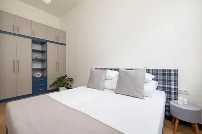a bedroom with a white bed and a blue cabinet at 1-bedroom apartment - Augustiańska 1 street in Kraków