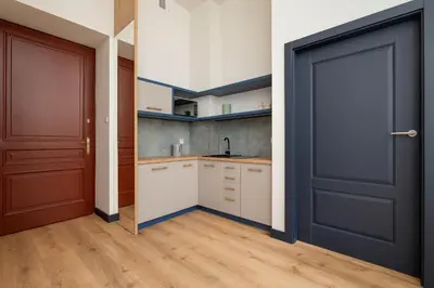 a kitchen with a black door and a wooden floor at 1-bedroom apartment - Augustiańska 1 street in Kraków