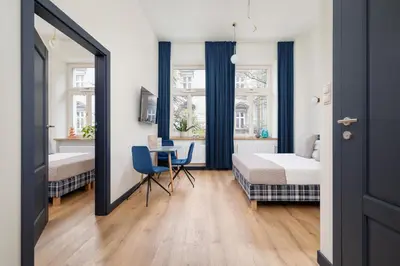 a bedroom with a bed and a desk and a table at 1 bedroom apartment - Augustiańska 1 in Kraków