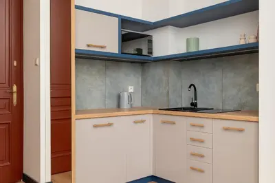 a kitchen with white cabinets and a sink at 1 bedroom apartment - Augustiańska 1 in Kraków