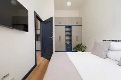 a bedroom with a white bed and a blue door at 1 bedroom apartment - Augustiańska 1 in Kraków